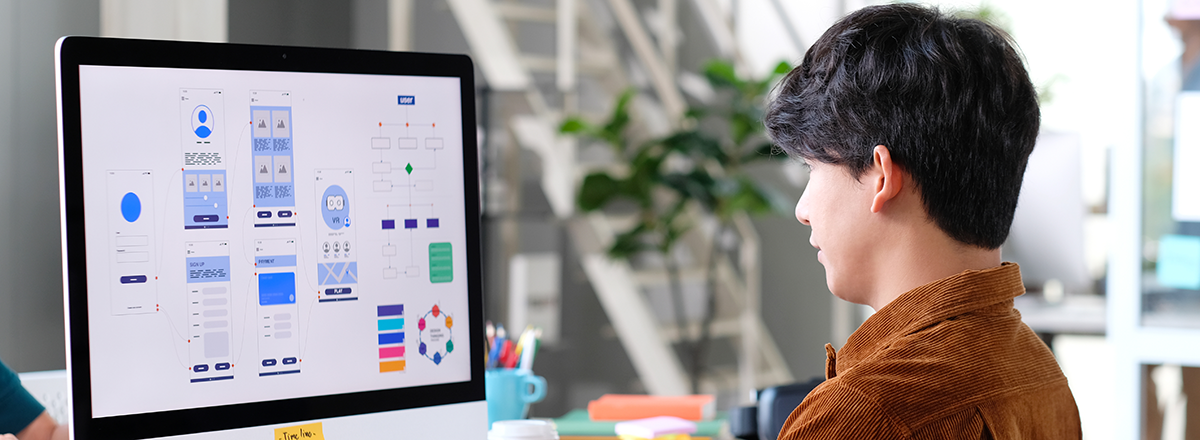 Man designing a web page on a computer.