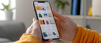 A woman looks at products generated by an AI agent on a smartphone in her living room.